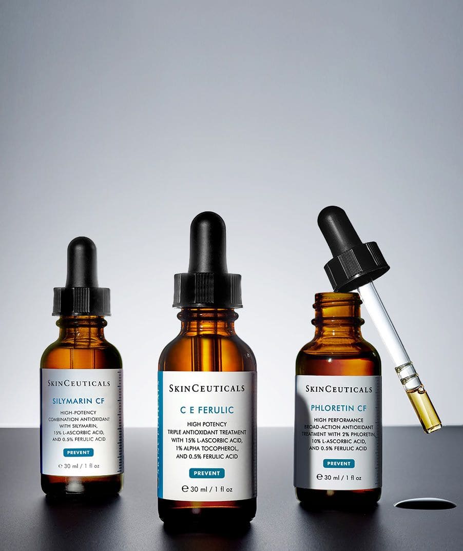 Tre SkinCeuticals-serum i brune pipetteflasker på rad